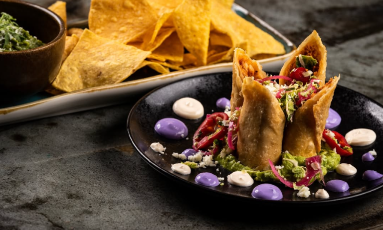 Crispy chicken flautas at La Neta Cocina y Lounge in Downtown Summerlin, Las Vegas, served with guacamole, Brussels slaw, citrus crema, and colorful garnishes — the best flautas in Las Vegas near Red Rock Casino Resort and Spa.