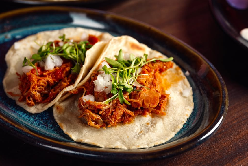 Carnitas taco in Las Vegas served at La Neta with braised pork, onions, and fresh microgreens on warm tortillas.