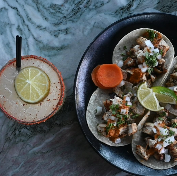 Grilled chicken Taquero Mucho taco platter by La Neta with fresh toppings and a handcrafted cocktail, ideal for anyone looking for a flavorful taco platter in Las Vegas